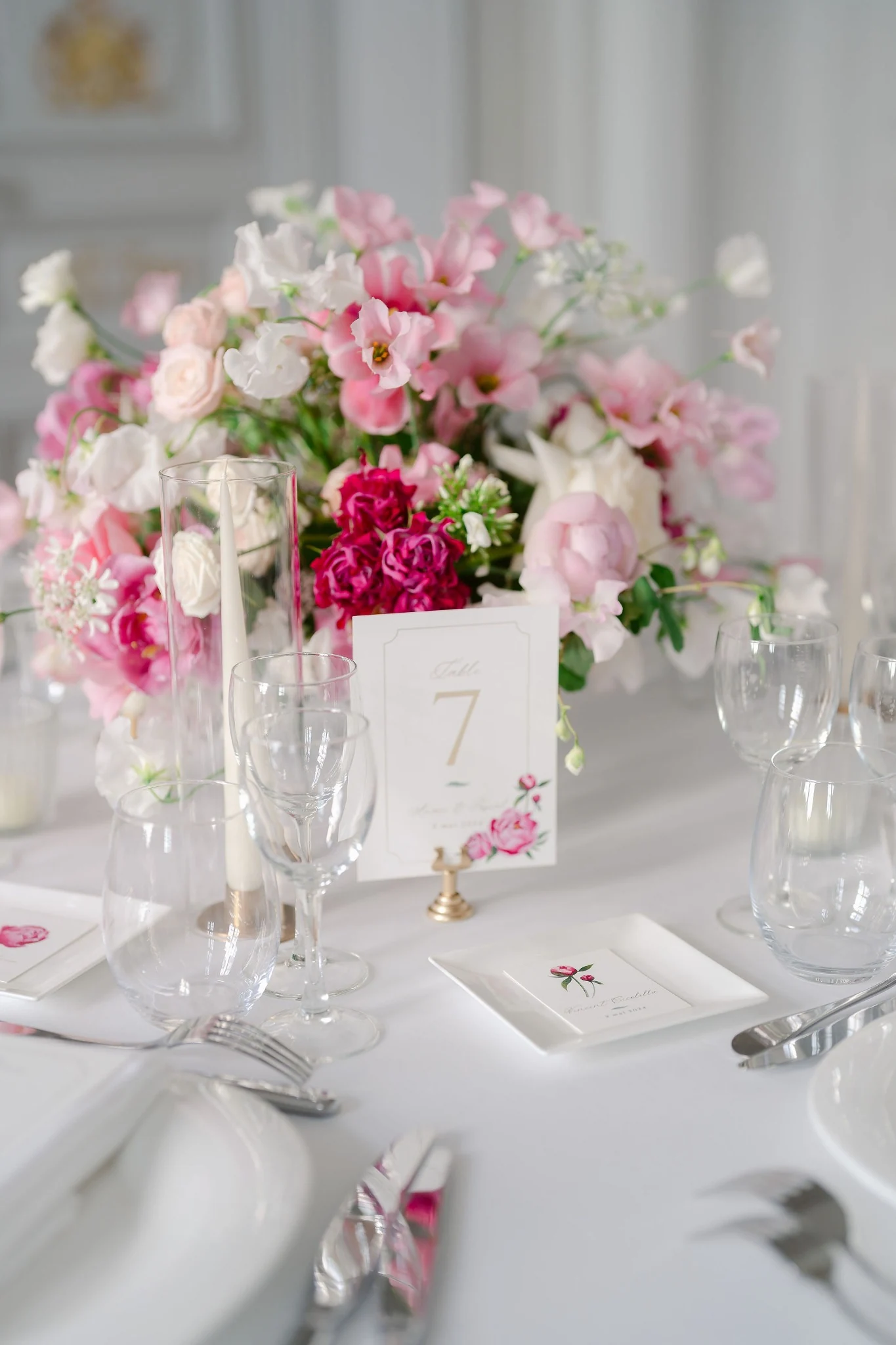 Close-up of table number seven with pink wedding flowers