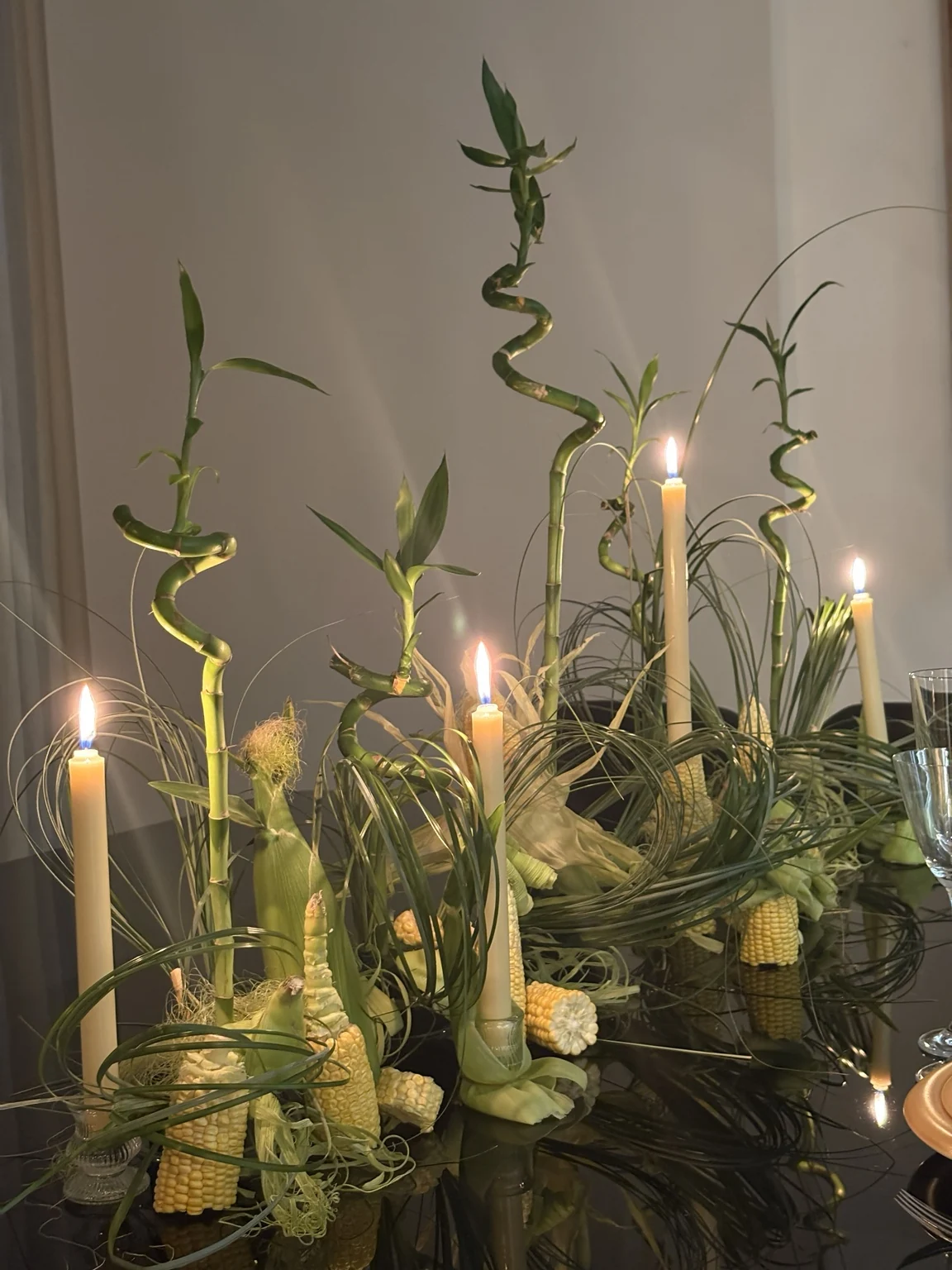 Mise en scène organique avec feuilles de maïs et bougies