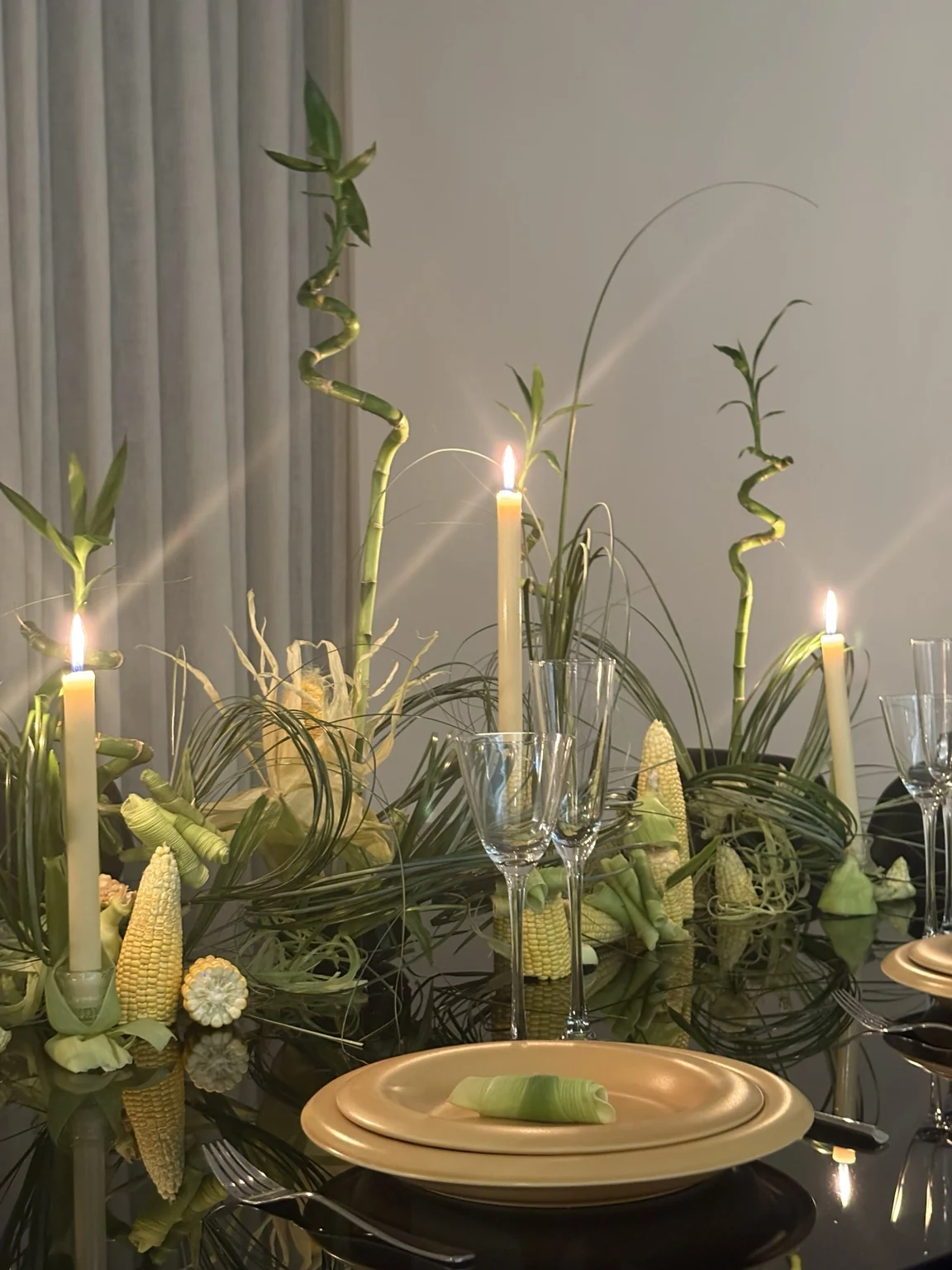 Table éditoriale avec bambou, feuillages verts et bougies