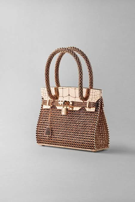 Hermès editorial reference: an intricately patterned handbag against a neutral studio backdrop